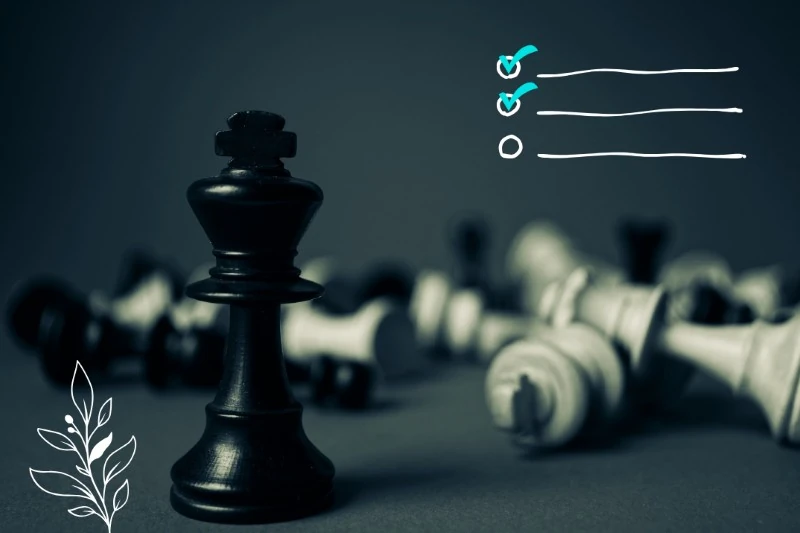 Black chess king on a board with several pieces knocked over on the floor, as if he were victorious. Checklist drawings.