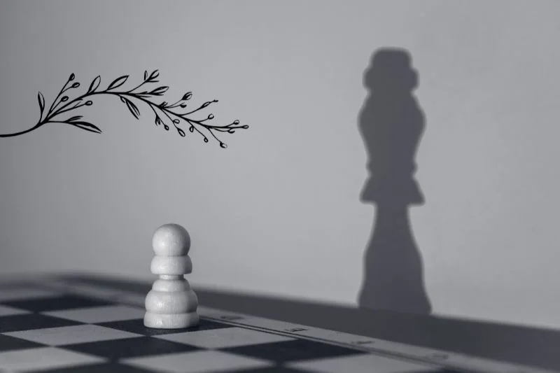 Peão em um tabuleiro de xadrez, projetando uma sombra de rei