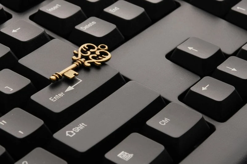 Chave dourada estilo vintage em cima de um teclado de computador preto.